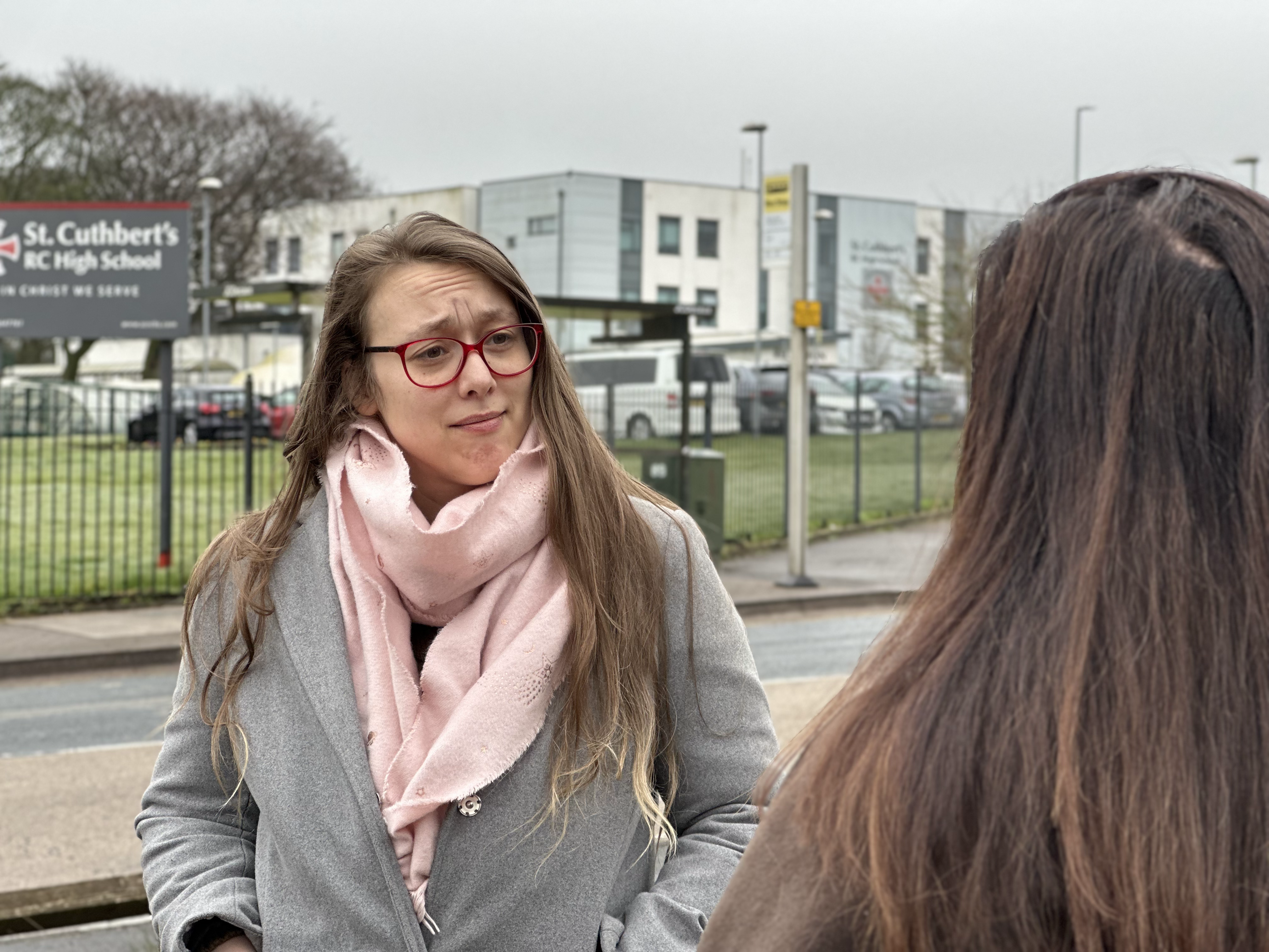 Chariss chatting with parents near a school